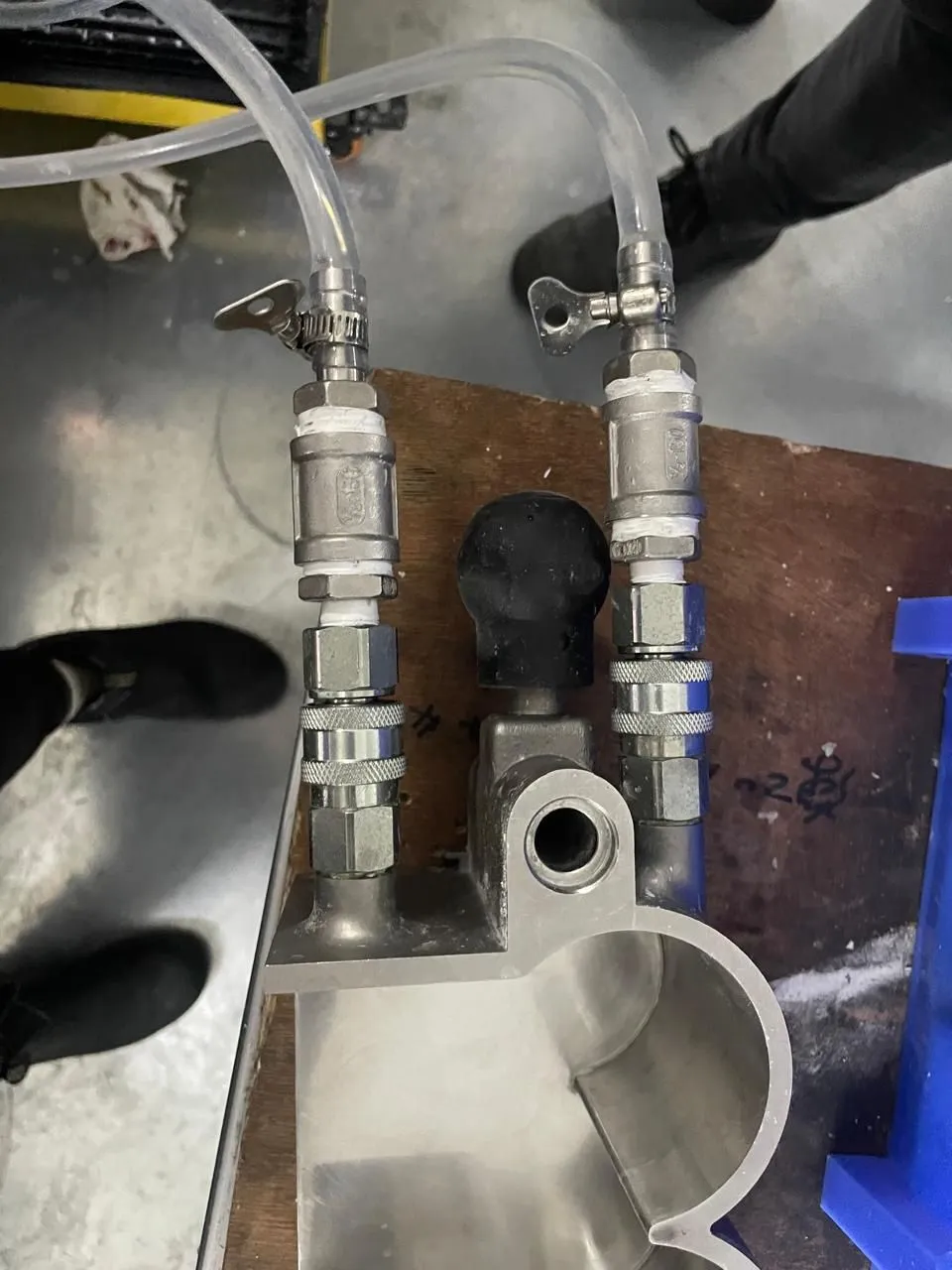 A quick-release coupling assembly with clear tubes, metal fittings, and valves.